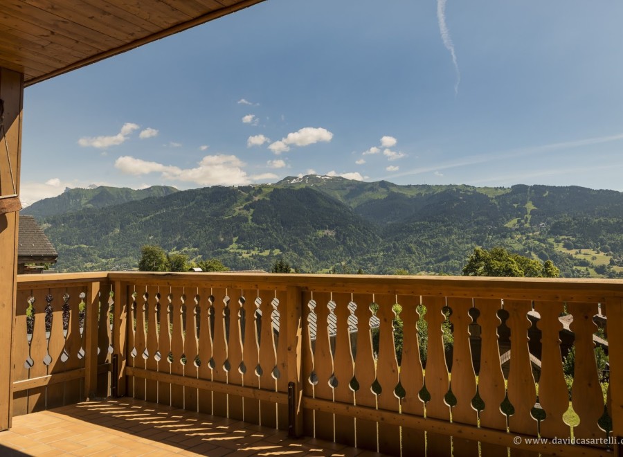 Mountain view balcony with wooden railings.
