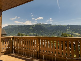 Mountain view balcony with wooden railings.
