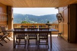 Mountain view dining on a wooden deck with folding chairs and a telescope.