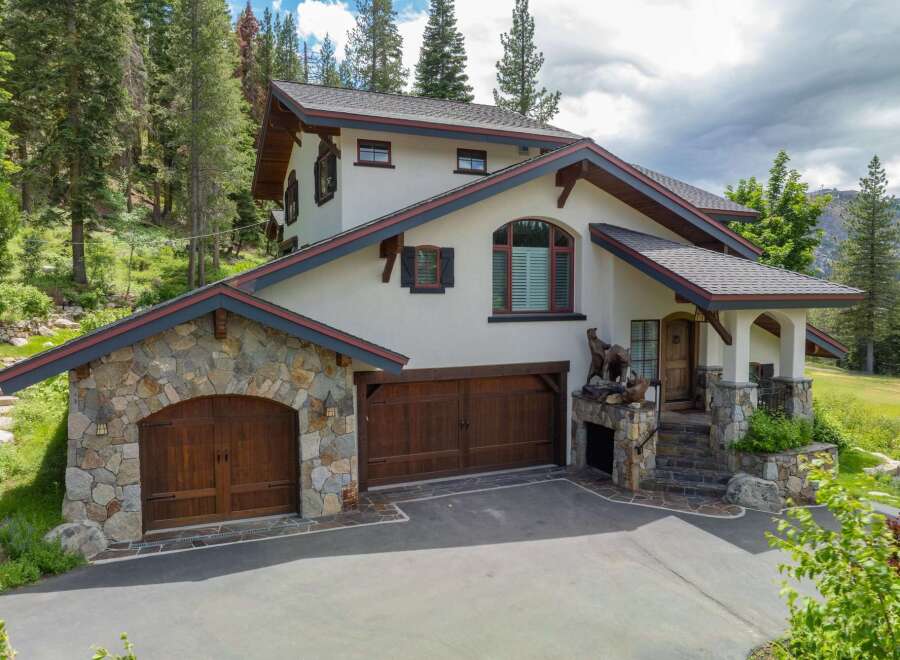 Discover luxury living in this stunning mountain retreat! This exquisite home boasts a beautiful stone facade, multiple garage spaces, and a charming covered entryway.