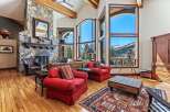 Experience luxury living in this stunning property, featuring a grand stone fireplace and expansive windows that frame breathtaking mountain views.