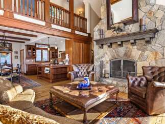 Step into luxury with this stunning property featuring a grand stone fireplace, perfect for cozy evenings.