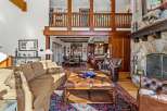 Step into luxury with this stunning property featuring a grand stone fireplace and a cozy leather armchair, perfect for relaxing evenings.