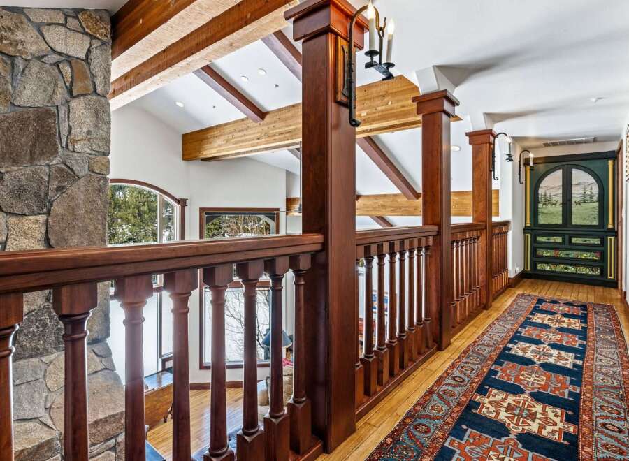 This stunning property boasts a beautifully designed interior with exquisite wooden accents and a captivating stone fireplace.