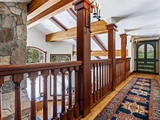 This stunning property boasts a beautifully designed interior with exquisite wooden accents and a captivating stone fireplace.