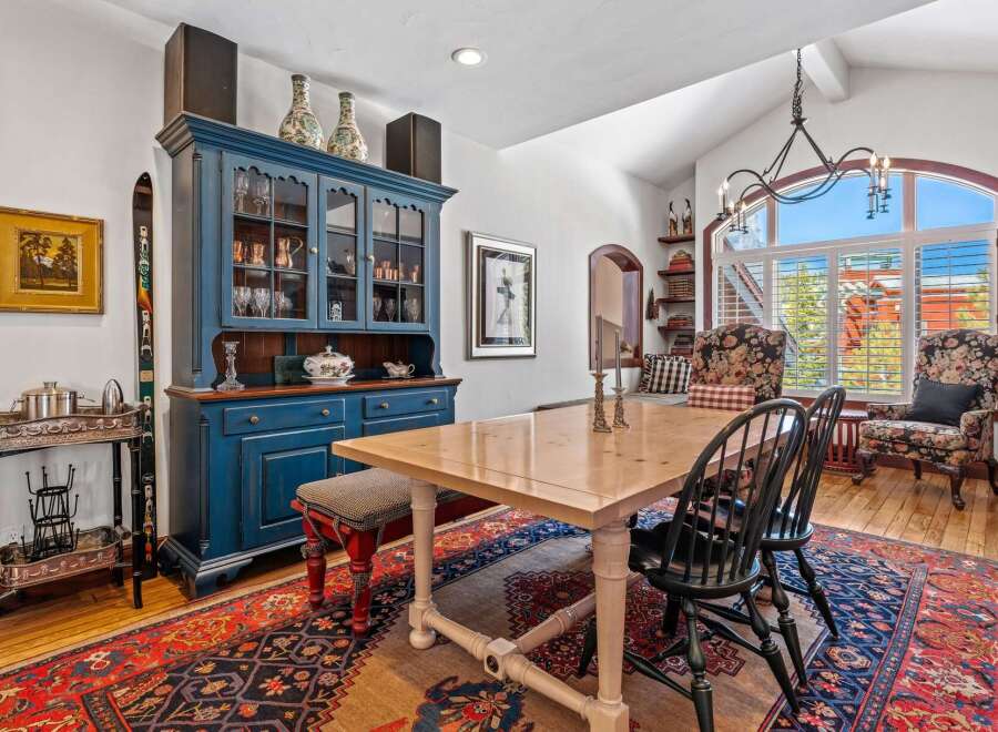 Step into this elegant dining room, featuring a stunning blue hutch and a beautiful wooden dining table.