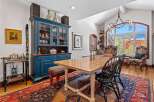Step into this elegant dining room, featuring a stunning blue hutch and a beautiful wooden dining table.