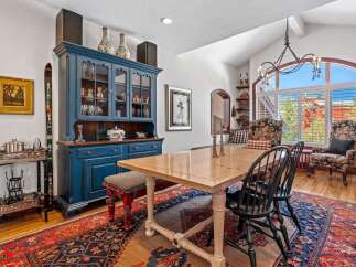 Step into this elegant dining room, featuring a stunning blue hutch and a beautiful wooden dining table.