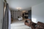 This stunning property boasts a spacious living area with large windows, allowing ample natural light to flood the room.