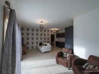This stunning property boasts a spacious living area with large windows, allowing ample natural light to flood the room.