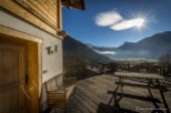 Mountain view chalet with wooden deck and bench.