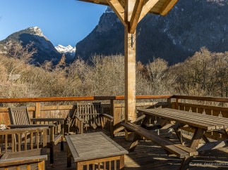 Mountain view deck with wooden picnic table and chairs.