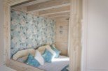 Romantic bedroom with floral wallpaper and light wood walls.