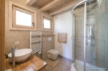 This stunning bathroom boasts a spacious shower enclosure, modern sink and toilet, and heated towel rack.