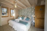 Charming bedroom with floral wallpaper and wooden beams.