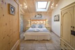 Charming bedroom with wooden beams, skylights, and a cozy atmosphere.