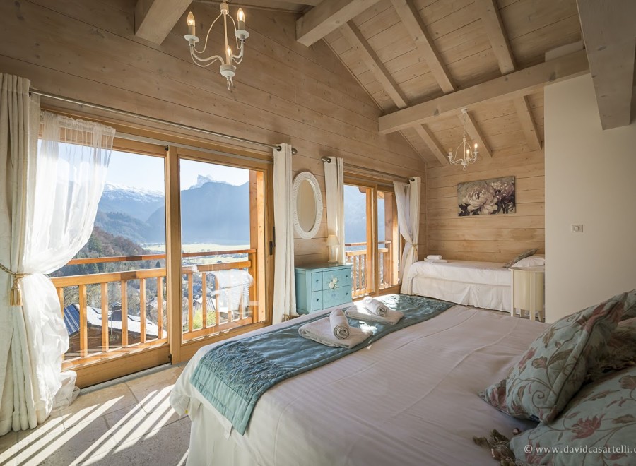 Wake up to breathtaking mountain views from this luxurious chalet bedroom.
