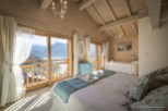 Wake up to breathtaking mountain views from this luxurious chalet bedroom.