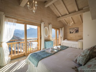 Wake up to breathtaking mountain views from this luxurious chalet bedroom.