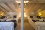 Cozy chalet bedrooms with twin beds, featuring elegant bedding and warm lighting.