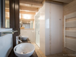 This luxurious bathroom boasts a double vanity with sleek sinks and modern fixtures.