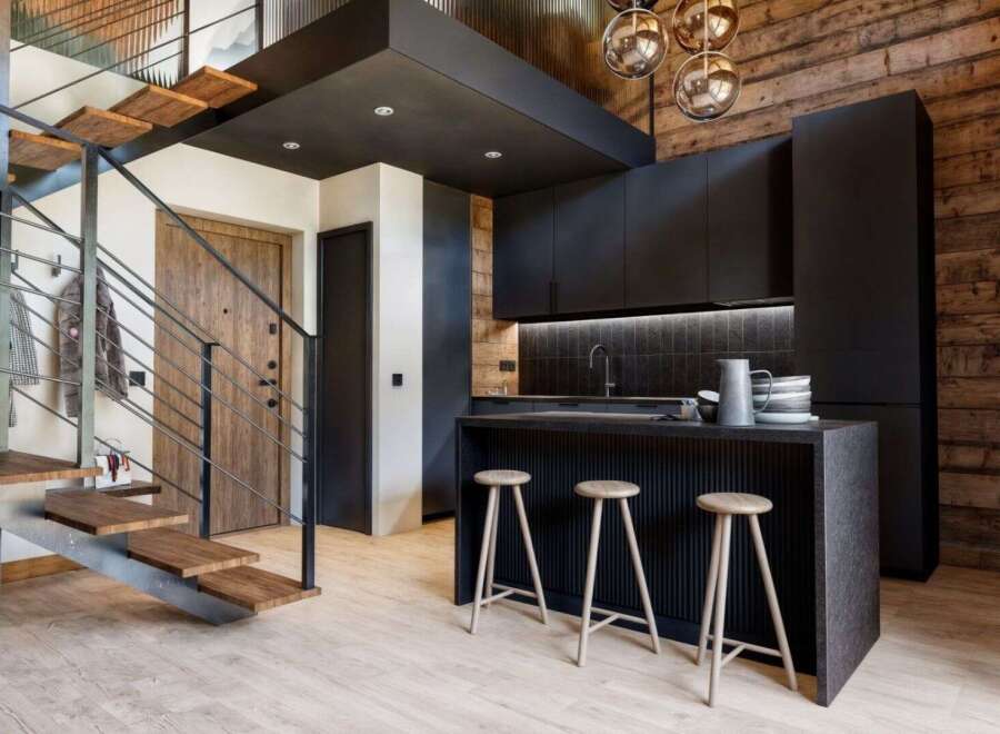 Discover modern living in this stunning property, featuring a sleek kitchen with black cabinetry and a stylish breakfast bar.