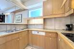 This charming kitchen features light wood cabinetry and a tiled backsplash, creating a warm and inviting atmosphere.