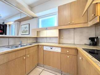 This charming kitchen features light wood cabinetry and a tiled backsplash, creating a warm and inviting atmosphere.