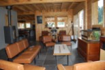 This stunning chalet boasts a spacious open-plan living area with exposed wooden beams and a cozy wood-burning stove.