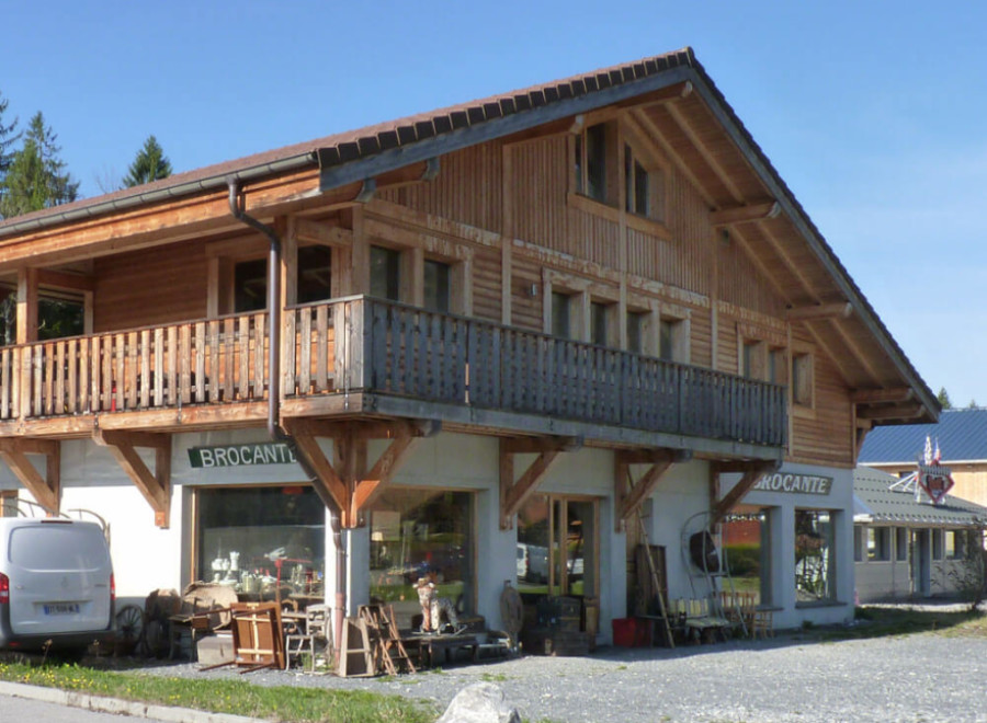 This charming chalet-style building boasts a spacious balcony, large windows, and ample parking.