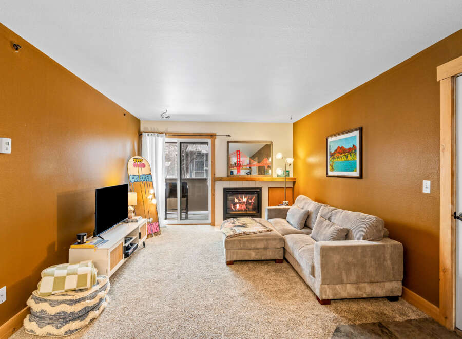 Step into this inviting living space, featuring a cozy fireplace and a comfortable sectional sofa, perfect for relaxing evenings.