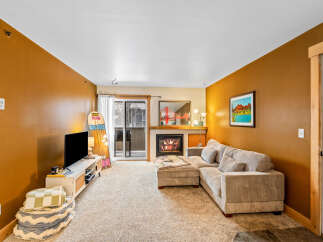 Step into this inviting living space, featuring a cozy fireplace and a comfortable sectional sofa, perfect for relaxing evenings.