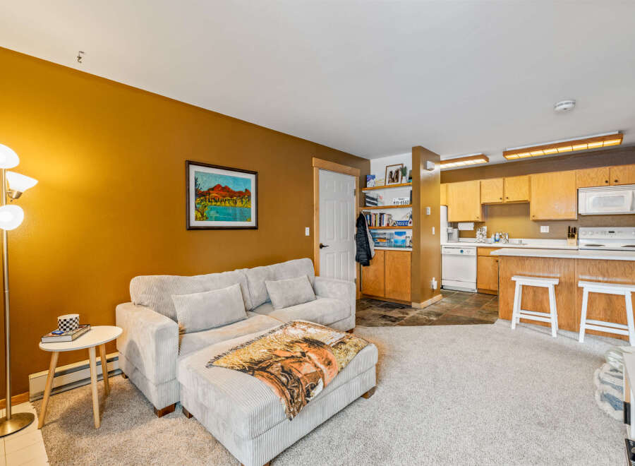 Step into this inviting living space, featuring a cozy sectional sofa and a warm, inviting color palette.