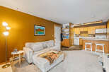 Step into this inviting living space, featuring a cozy sectional sofa and a warm, inviting color palette.