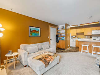 Step into this inviting living space, featuring a cozy sectional sofa and a warm, inviting color palette.