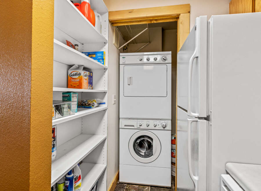 Discover the convenience of this home featuring a dedicated laundry area with a stacked washer and dryer, perfect for efficient chores.