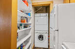 Discover the convenience of this home featuring a dedicated laundry area with a stacked washer and dryer, perfect for efficient chores.