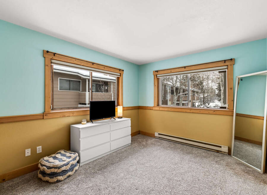 This inviting bedroom boasts a serene atmosphere with its calming color palette and ample natural light.