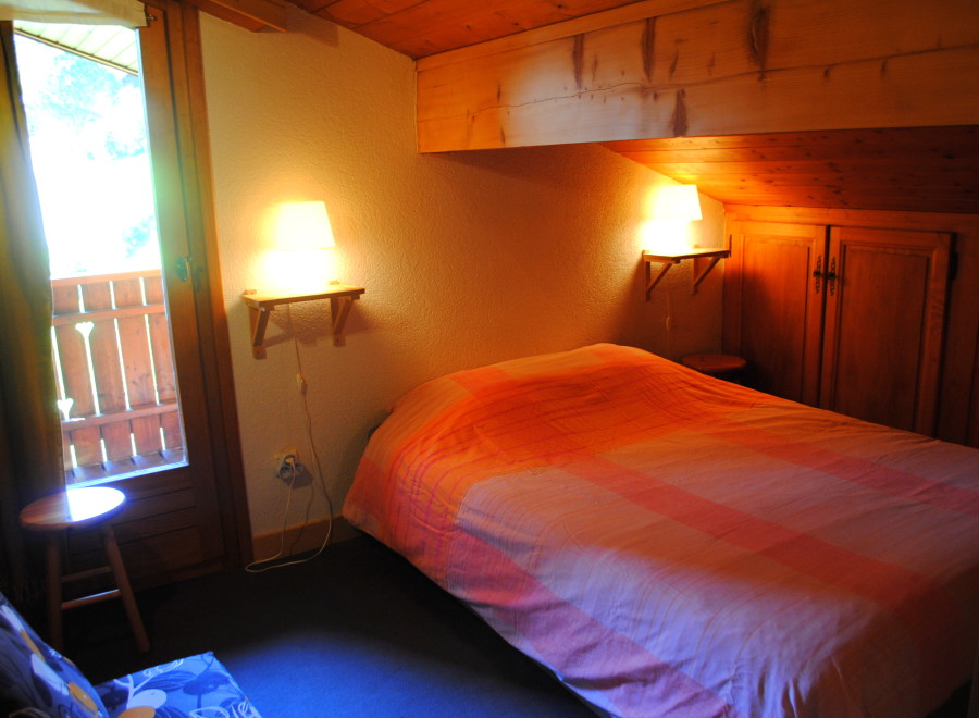 Cozy chalet bedroom with wooden accents and a comfortable bed.