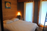 Cozy bedroom with wooden walls and white bedding.