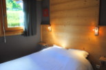 Cozy bedroom with wooden walls and a comfortable bed.