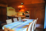 Cozy chalet kitchen with wooden cabinets and a dining area featuring a checkered tablecloth.