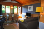 This charming chalet boasts a spacious living area with a comfortable sofa and flat-screen TV, perfect for relaxing after a day of outdoor activities.