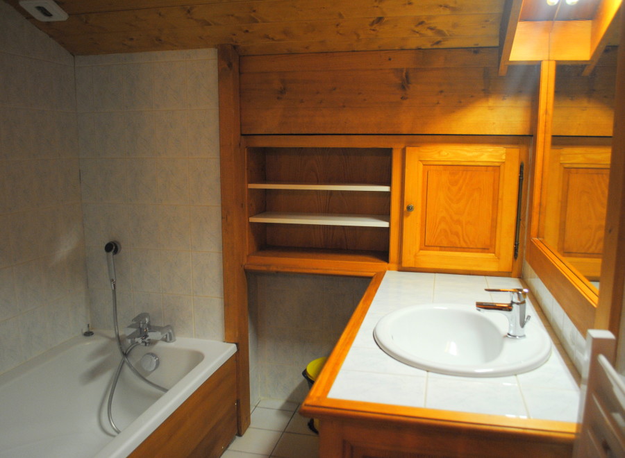 Charming bathroom with wooden cabinetry and tiled walls.