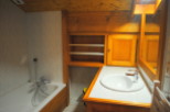 Charming bathroom with wooden cabinetry and tiled walls.