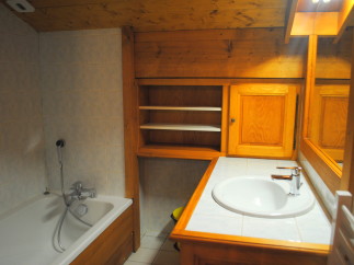 Charming bathroom with wooden cabinetry and tiled walls.