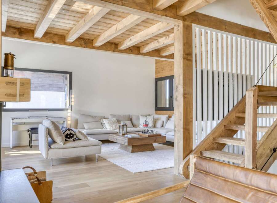 This stunning property boasts a warm and inviting interior with exposed wooden beams and a cozy fireplace.