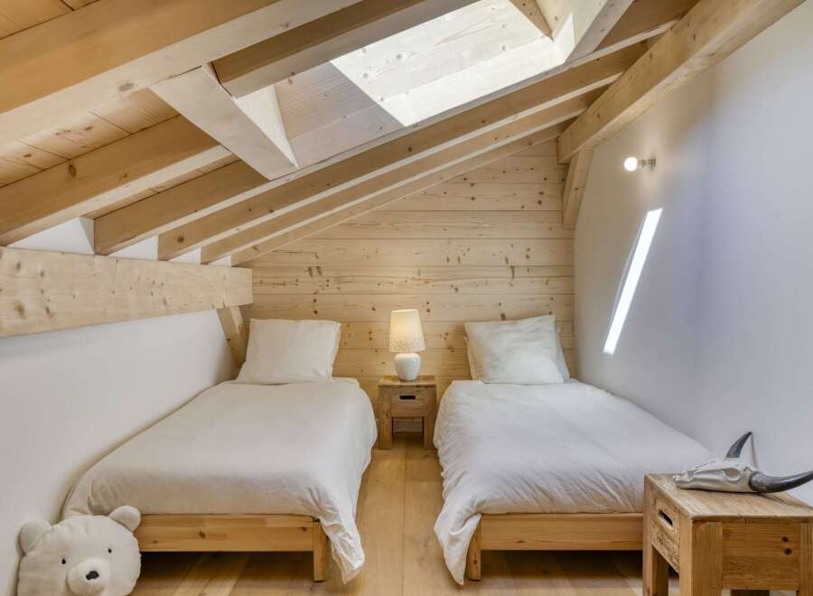 Discover the charm of this cozy bedroom, featuring a unique sloped ceiling and exposed wooden beams.