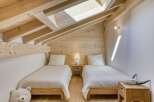 Discover the charm of this cozy bedroom, featuring a unique sloped ceiling and exposed wooden beams.