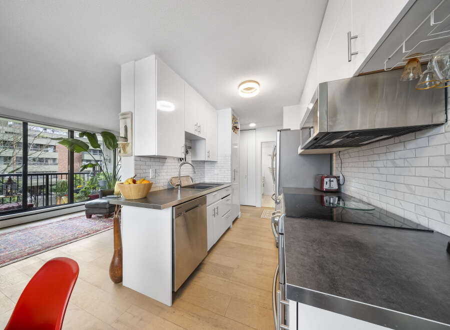 This modern kitchen boasts sleek white cabinetry, stainless steel appliances, and a stylish countertop.